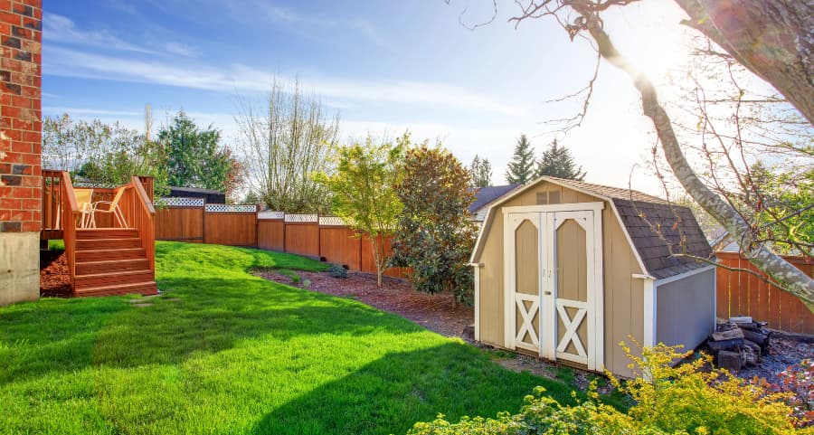 Fenced backyard with storage shed in St. George